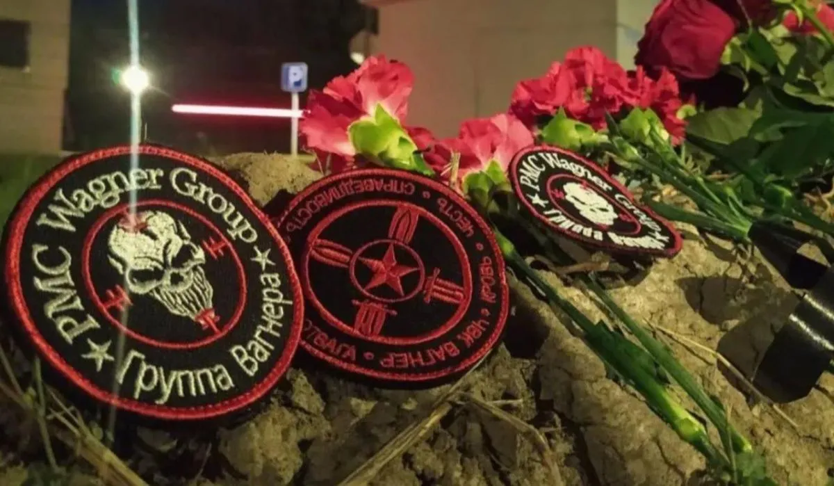 Жители Петербурга несут цветы к стихийному мемориалу у офиса «ЧВК Вагнер Центра»